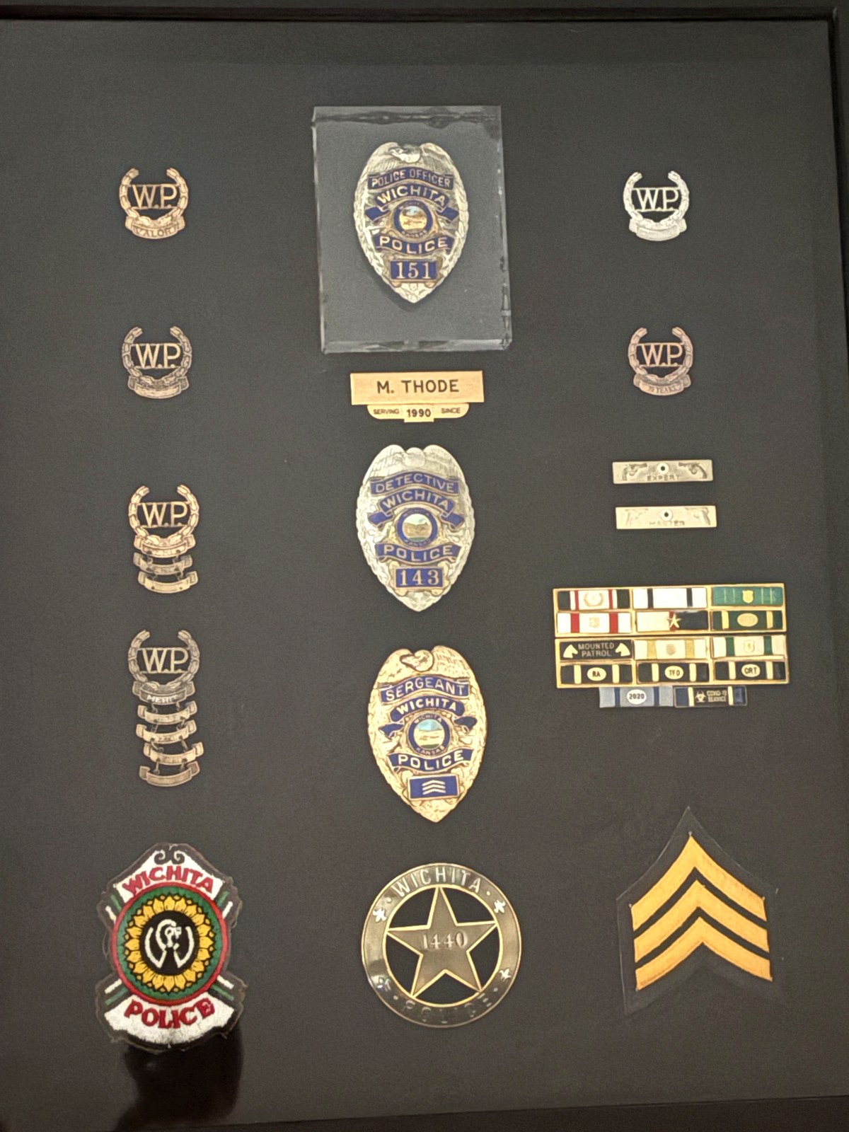 Mike Thode's career shadow box: Wichita Police officer, detective and sergeant badges, W.P. collar insignia, patches, service ribbons and sergeant chevrons