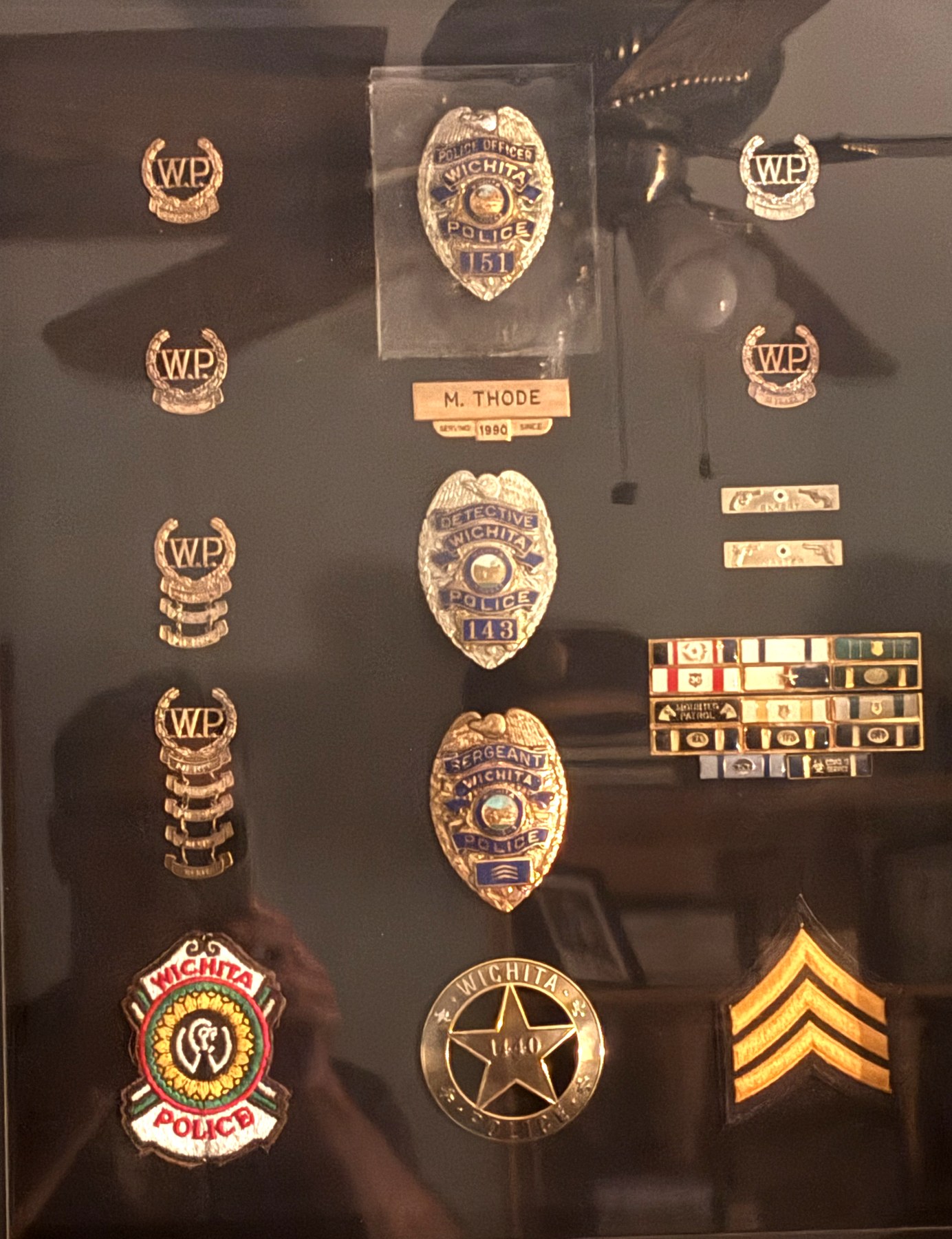 Mike Thode's career shadow box: Wichita Police badges, W.P. collar insignia, patches, service ribbons and sergeant chevrons